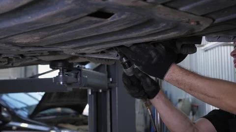 An auto mechanic repairing brake pads on a car wheel at a service station. Stock Footage 300831353