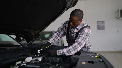 Auto mechanic repairing engine in car workshop Stock Footage 300608203