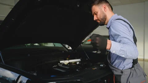 Auto mechanic repairing engine in modern vehicle workshop Stock Footage 300613203