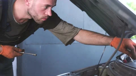 Auto mechanic repairs a car. engine repair. repair station. 動画素材 205231977