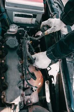 Auto mechanic repairs car engine. Man's hands in work gloves close-up. Diagno Fotos de archivo