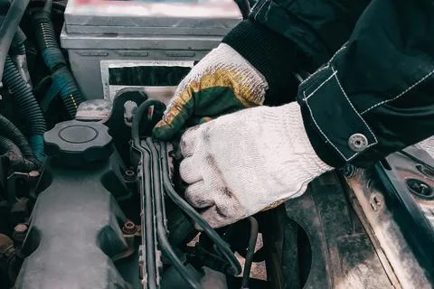 Auto mechanic repairs car engine. Man's hands in work gloves close-up. Diagno Stock Photos