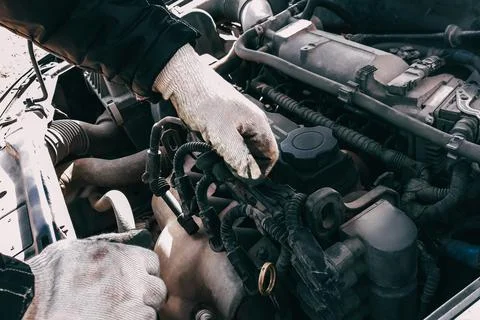 Auto mechanic repairs car engine. Man's hands in work gloves close-up. Diagno Fotos de archivo