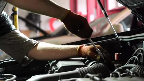 Auto mechanic repairs SUV engine. auto repair station. close-up 動画素材 204877392