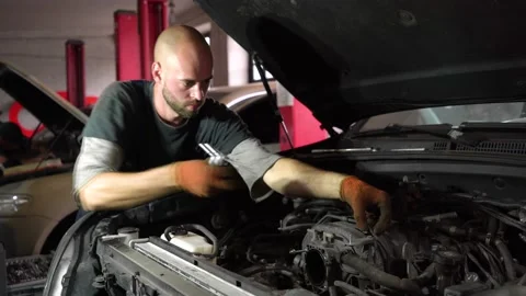 Auto mechanic repairs SUV engine. auto repair station. Stock Footage 205232380