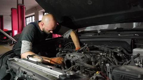Auto mechanic repairs SUV engine. auto repair station. Stock Footage 206078521