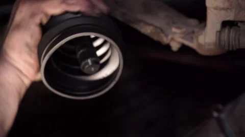 Auto mechanic replaces CV joint boot Stock Footage 307601232