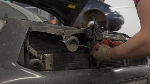 Auto mechanic replaces engine bonnet lock Stock Footage 102985185