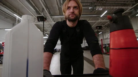 An auto mechanic rolls a cart with tools around the workshop Stock Footage 221545320