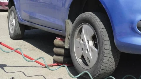 An auto mechanic secures a car wheel with a torque wrench to ensure accuracy. Stock Footage 273450899