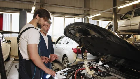 Auto mechanic shows engine error codes to a male customer in a car service 스톡 동영상 243363714