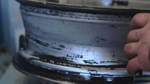 Auto mechanic smears a car disc with a sealant when installing a tire. Stock Footage 169944648