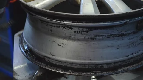 An auto mechanic smears a car disc with a sealant when installing a tire. Stock Footage 169944759