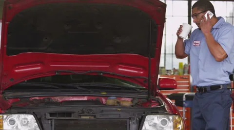 Auto mechanic talking on cell phone Stock Footage 61676470