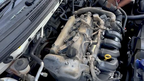 Auto mechanic testing and checking ignition coils of a car engine Stock Footage 264260995