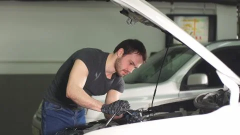Auto mechanic testing electrical system on automobile. Foto stock