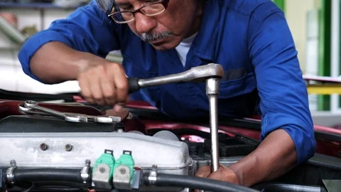 Auto mechanic tighten bolt of engine car with torque wrench in car garage. Stock Footage 119418856