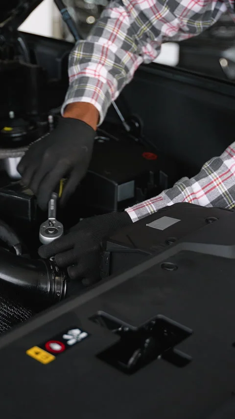 Auto mechanic tightening engine components under work lamp Stock Footage 300613649