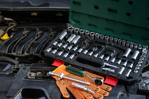 Auto mechanic tools under the open hood of the car Stock Photos