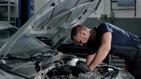 Auto mechanic twisting bolts to remove gearbox for repair in modern car.  Stock Footage 239471044