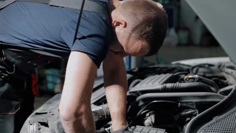 Auto mechanic twisting bolts to remove gearbox for repair in modern car. Stock Footage 239471045