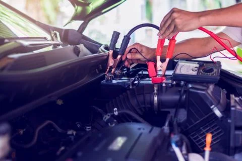 Auto mechanic use voltmeter to check voltage level in car battery. Auto mecha Stock-Fotos