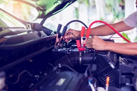 Auto mechanic use voltmeter to check voltage level in car battery. Auto mecha Stock Photos