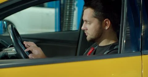 Auto mechanic uses tablet computer to inspect technical condition sitting behind 스톡 사진