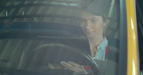 Auto mechanic uses tablet computer to inspect technical condition sitting behind 스톡 사진