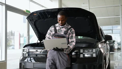 Auto mechanic using laptop for car diagnostics in workshop Stock Footage 300611316