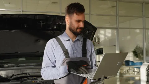 Auto mechanic using laptop for car diagnostics in workshop Stock Footage 300612351