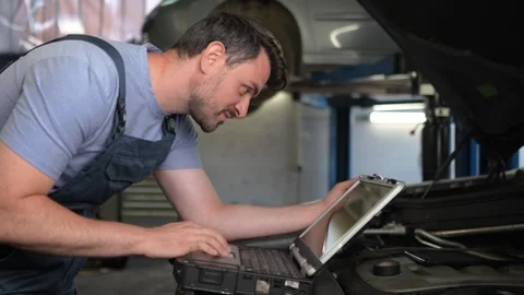 Auto mechanic using a laptop to diagnose a car problem Stock Footage 316485069
