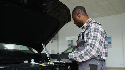 Auto mechanic using laptop for engine diagnostics in workshop Stock Footage 300611460