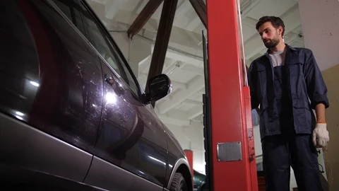 Auto mechanic using lift in car repair service 스톡 동영상 123506767