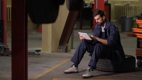 Auto mechanic using tablet to order car parts Stock Footage 123508137