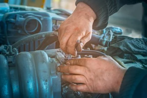 Auto mechanic working on car engine in mechanics garage. Repair service. Clos Stock Photos