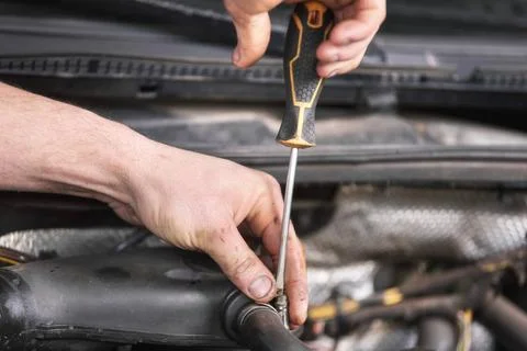 Auto mechanic working on car engine at repair service. Close up view. Auto... 库存照片