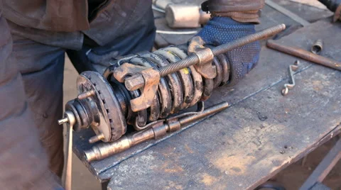 Auto mechanic working on shock absorber in garage Stock Footage 60631544