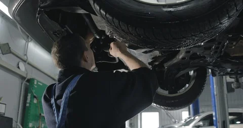 Auto Mechanic Working Under The Car In Dealer's Service. Stock-Footage 124968622
