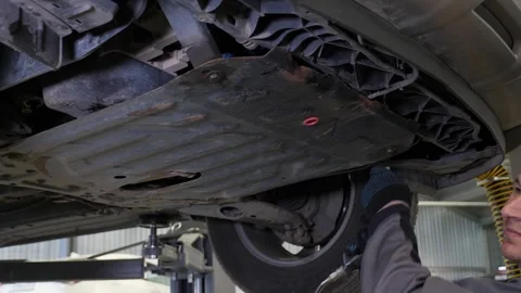 An auto mechanic working under the car on a car lift in the garage. Car service. Stock Footage 337733958