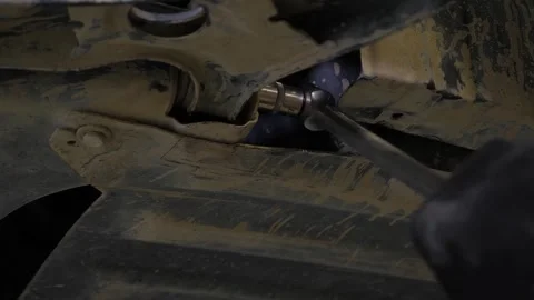 An auto mechanic working under a car on a car lift in a garage. Auto repair shop Stock Footage 337734100