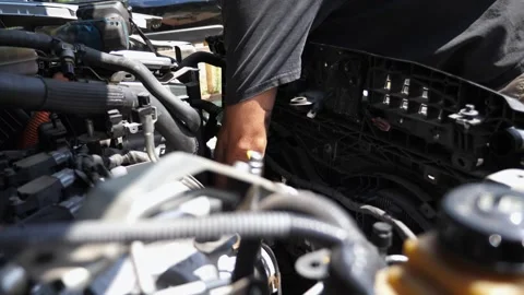 Auto mechanic working under hood of vehicle outdoor. Professional repairman Stock-Footage 304579598