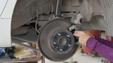 Auto mechanic's hands putting the break shoes back on Stock Footage 239744646
