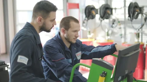 Auto Mechanics Performing Vehicle Diagnostics on Computer Stock Footage 299124785