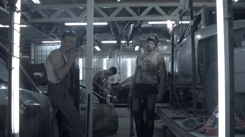 Auto mechanics team at work in garage in slow motion Stock Footage 56071126