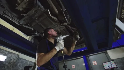 Auto mechanics working under the car hanging on lift. Auto repair concept. Stock Footage 95110318