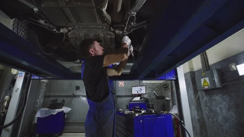 Auto mechanics working under the car hanging on lift. Auto repair concept. Stock Footage 95110331