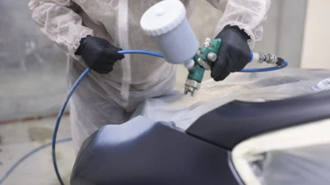 Auto painter spraying black paint on car wing in special booth. Painting vehicle Stock Footage 194802234