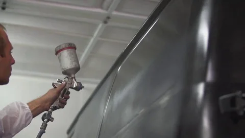 Auto painter spraying paint on car in special booth Stock Footage 85365045