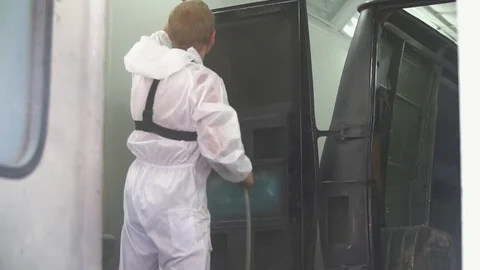 Auto painter spraying paint on car in special booth Stock Footage 85368934